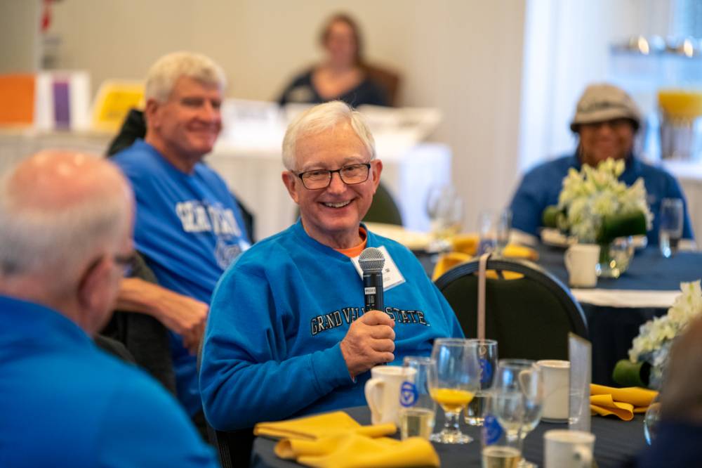 An alumnus speaking to the audience.